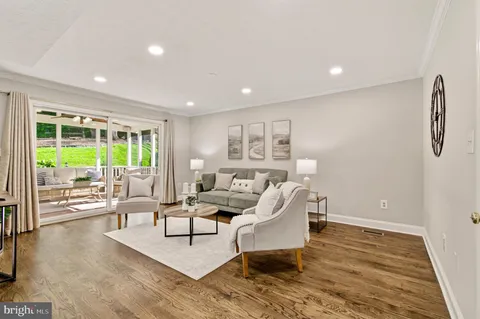 a living room filled with furniture and kitchen view