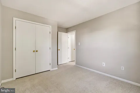 a spacious bedroom with a bed and a chandelier
