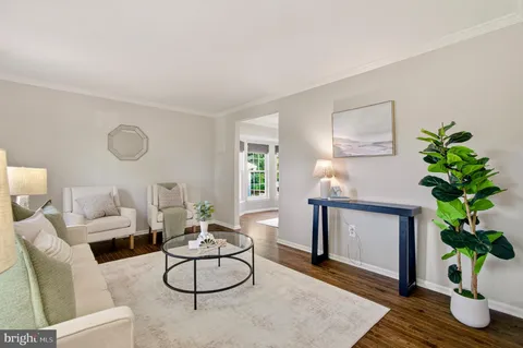 a living room with furniture a window and a potted plant