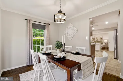 a dining room with furniture a chandelier and wooden floor