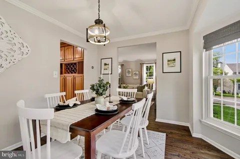 a view of a dining room with furniture a chandelier and wooden floor