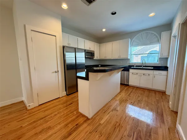 a kitchen with stainless steel appliances granite countertop a sink a stove and a refrigerator