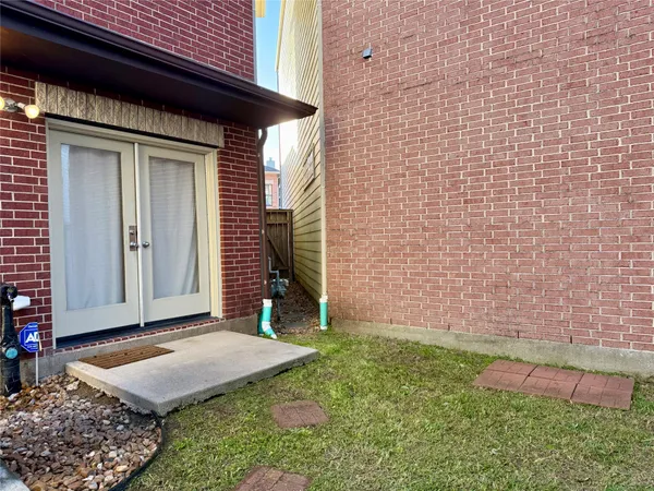 a view of a backyard with plants and wooden fence