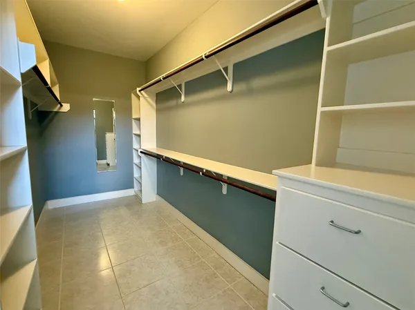 a view of an empty room with wooden floor and staircase