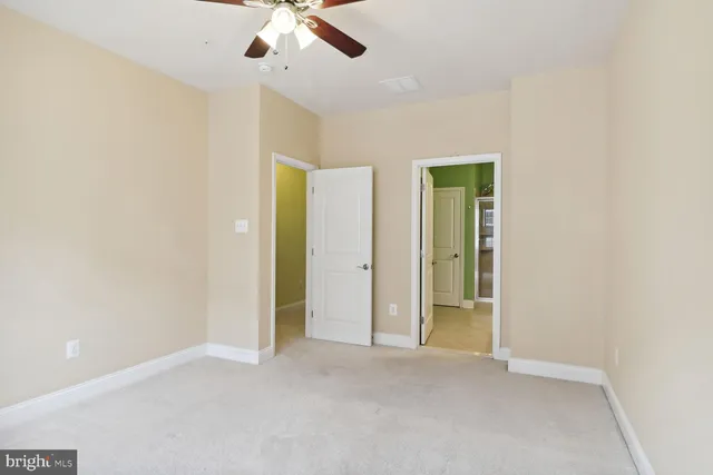 an empty room with chandelier fan