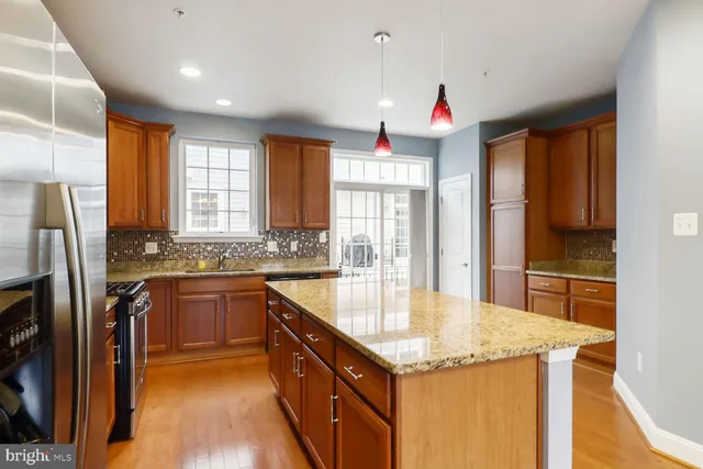 a kitchen with stainless steel appliances granite countertop a sink window and refrigerator
