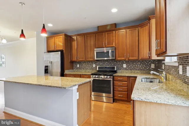 a kitchen with stainless steel appliances granite countertop a sink a stove and a microwave