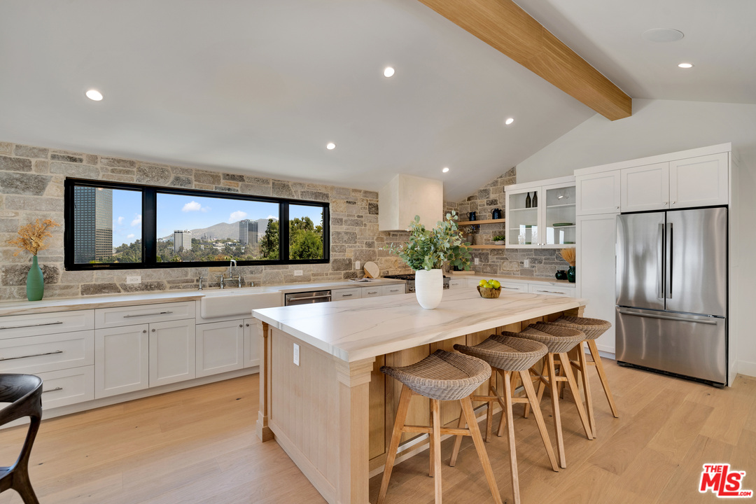 3614 Willowcrest Avenue Studio City, CA 91604 - Photo 15 of 43 a kitchen with stainless steel appliances kitchen island granite countertop a table chairs sink and cabinets