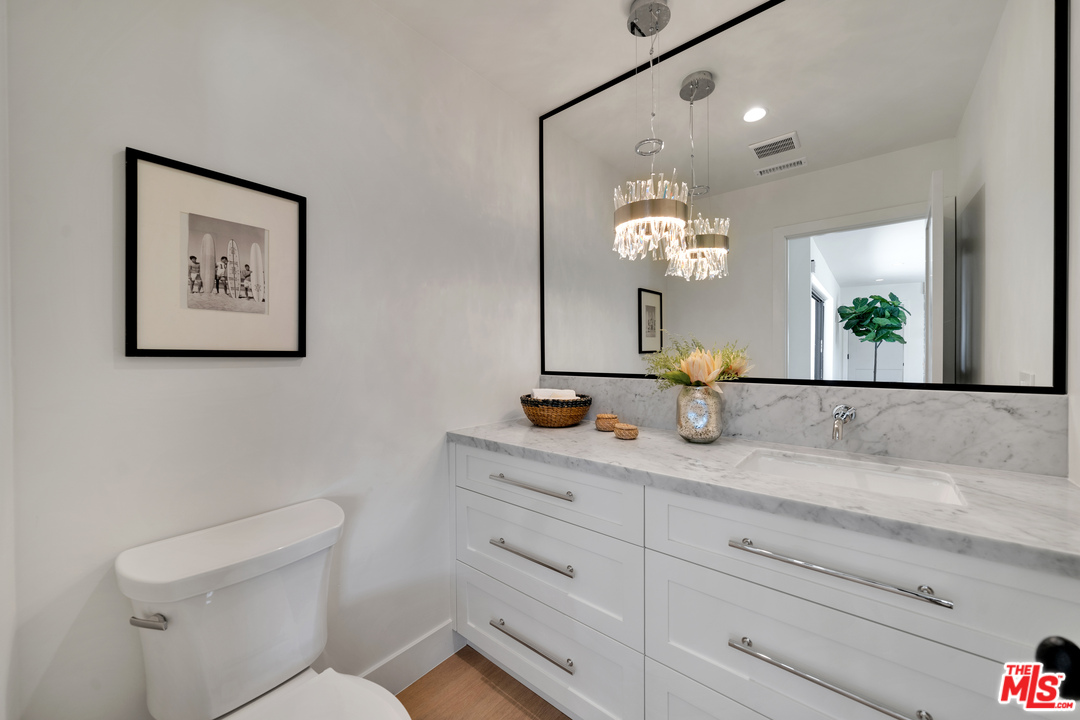 3614 Willowcrest Avenue Studio City, CA 91604 - Photo 32 of 43 a bathroom with a granite countertop sink a toilet and a mirror