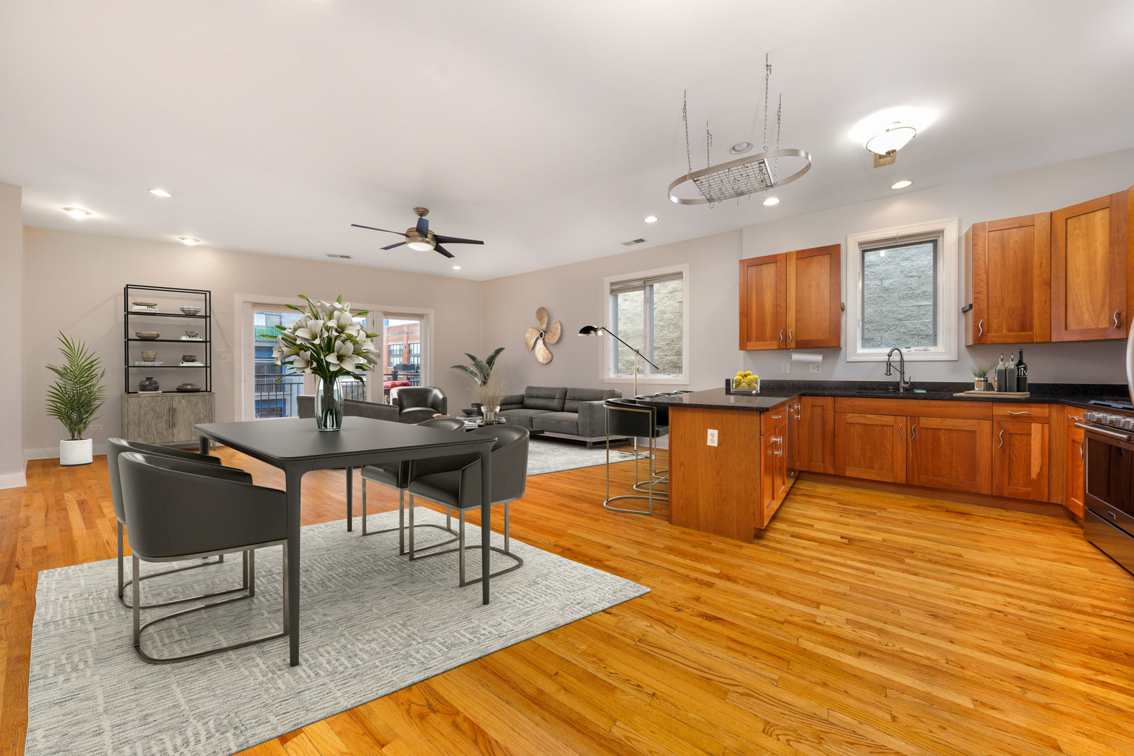 31 East 26th Street, Unit 5 Chicago, IL 60616 - Photo 7 of 40 a kitchen with stainless steel appliances kitchen island granite countertop a sink dishwasher a dining table and chairs with wooden floor
