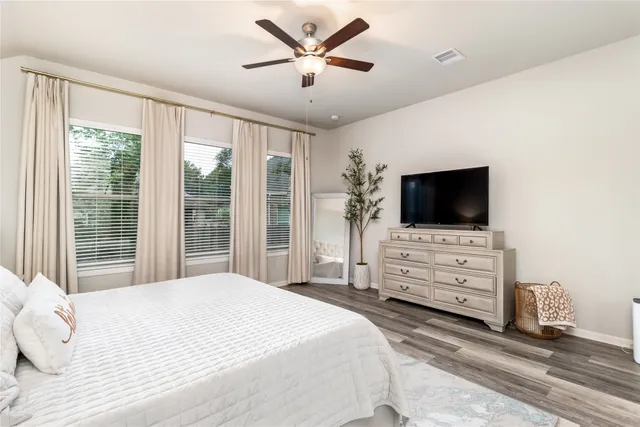 a bedroom with a bed tv and flat screen tv