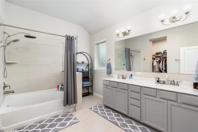 a bathroom with a tub sink double vanity granite tub and shower