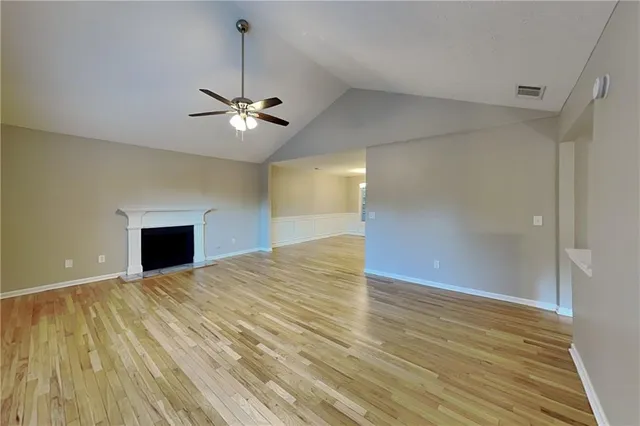 a view of a room with a ceiling fan and a hardwood