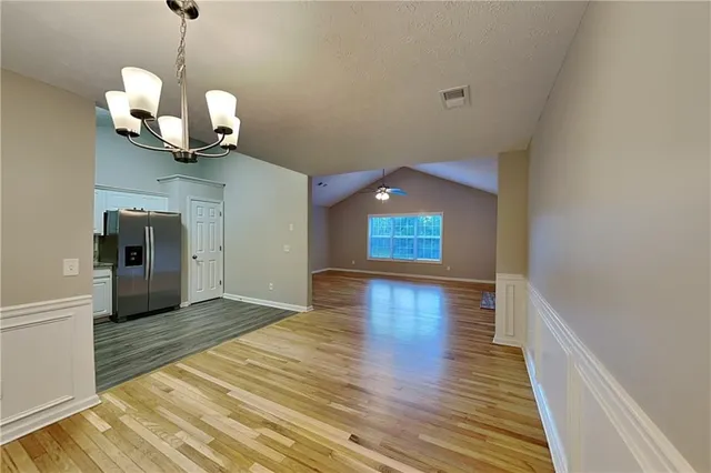a view of a room with wooden floor and a ceiling fan
