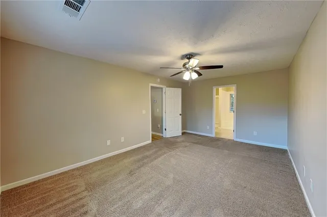 a view of an empty room with a chandelier fan