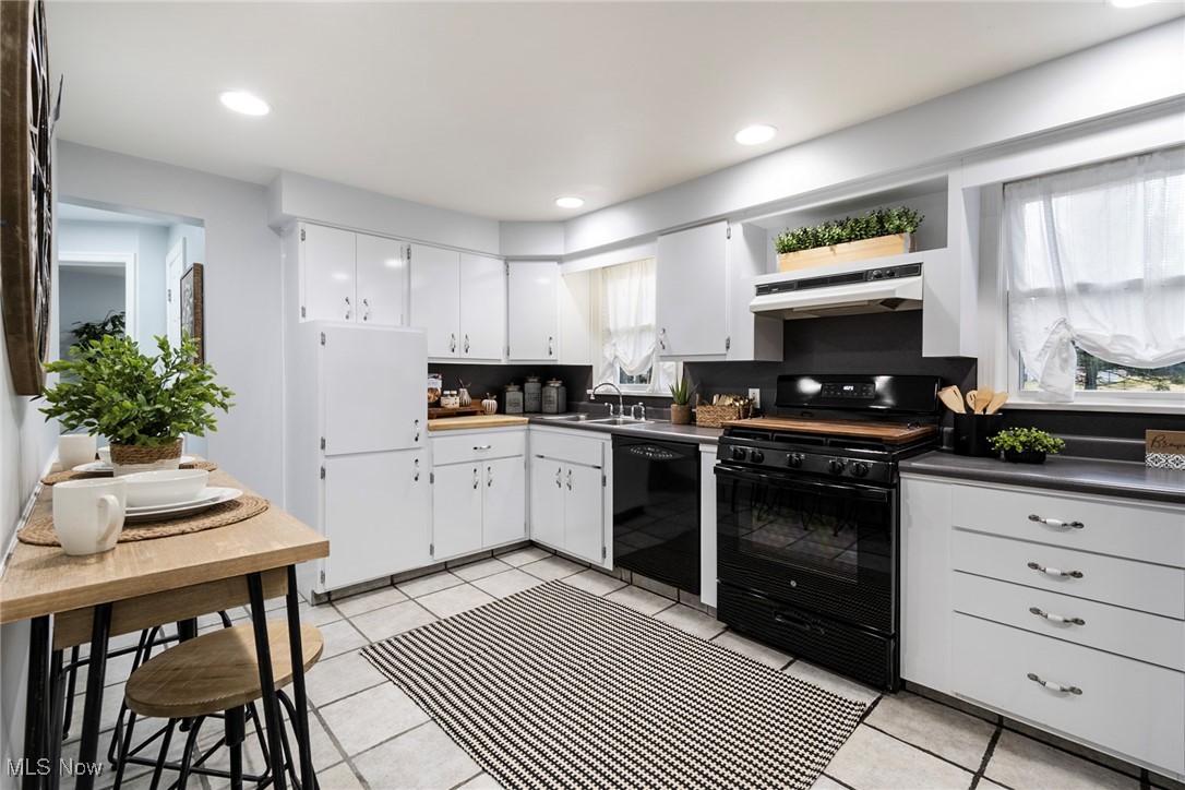 4188 Kirk Road Youngstown, OH 44511 - Photo 10 of 49 Kitchen featuring white cabinetry, light tile patterned flooring, sink, and black appliances