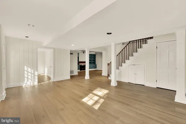 a view of empty room with wooden floor and window