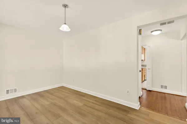 a view of a room with wooden floor and white walls