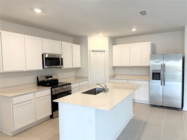 a kitchen with kitchen island a sink stainless steel appliances and cabinets