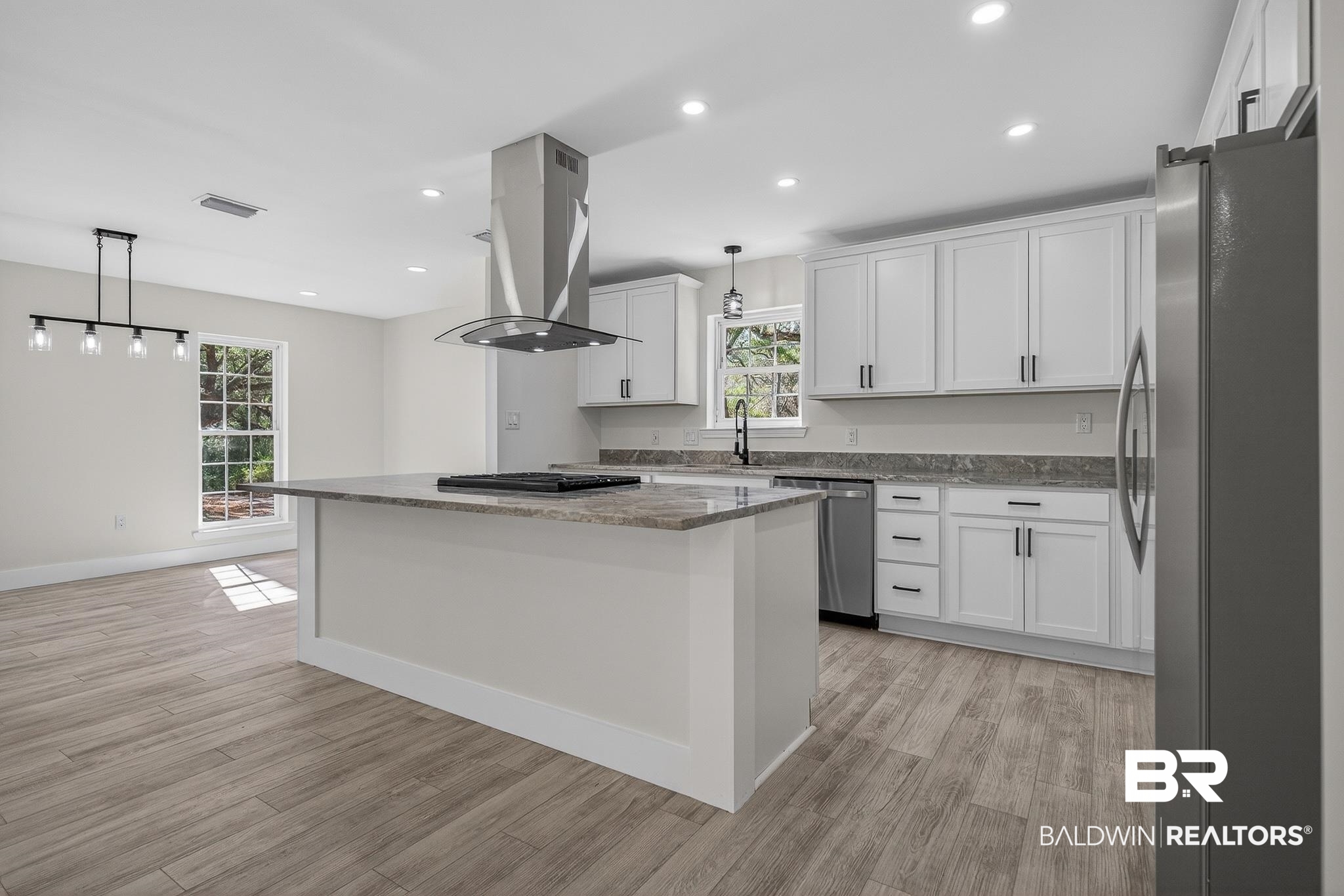 10650 Old Pascagoula Road Theodore, AL 36582 - Photo 20 of 77 Kitchen featuring dark stone counters, stainless steel appliances, decorative light fixtures, a center island, and white cabinetry