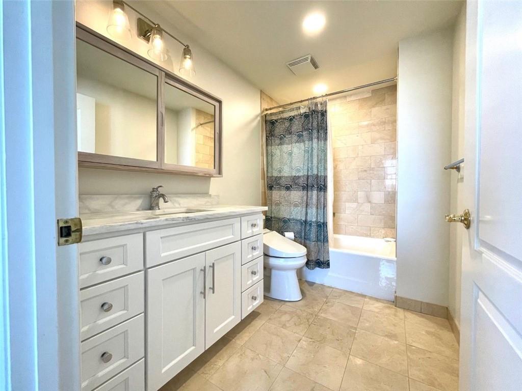 195 14th Street Northeast, Unit P603 Atlanta, GA 30309 - Photo 15 of 27 a spacious bathroom with a granite countertop sink mirror and a toilet
