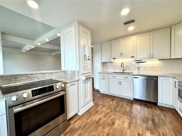 a kitchen with a stove top oven sink and cabinets