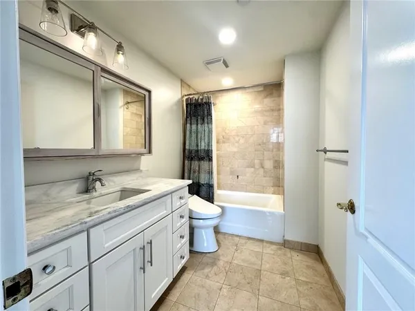 a bathroom with a double vanity sink toilet mirror and bathtub