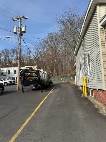 a view of a city street with a car parked on the road