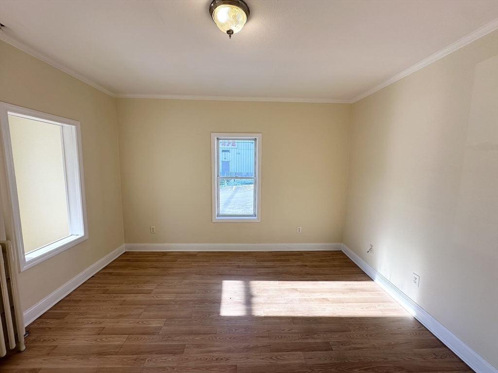255 River Street, Unit 1 Haverhill, MA 01832 - Photo 9 of 22 an empty room with wooden floor and windows