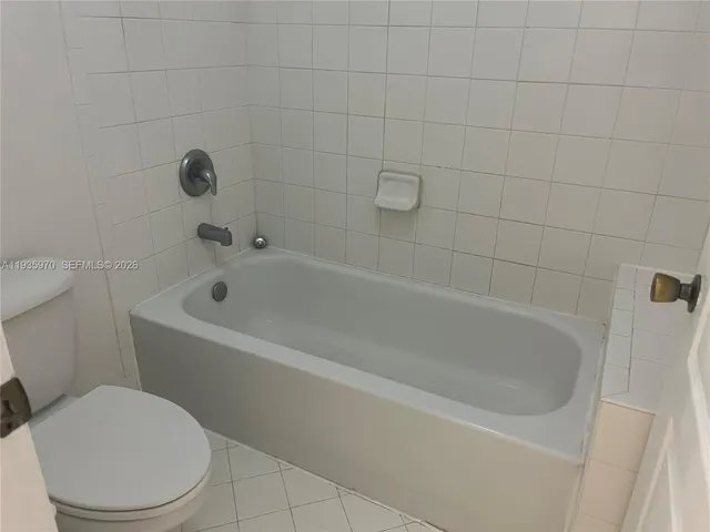 a white bath tub sitting next to a white toilet