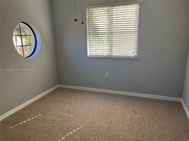 an empty room with a window and a mirror