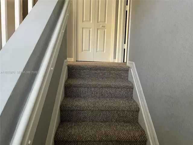 a view of staircase with white walls and a window