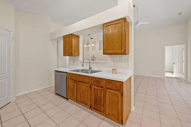 a view of an empty room with wooden floor and a ceiling fan