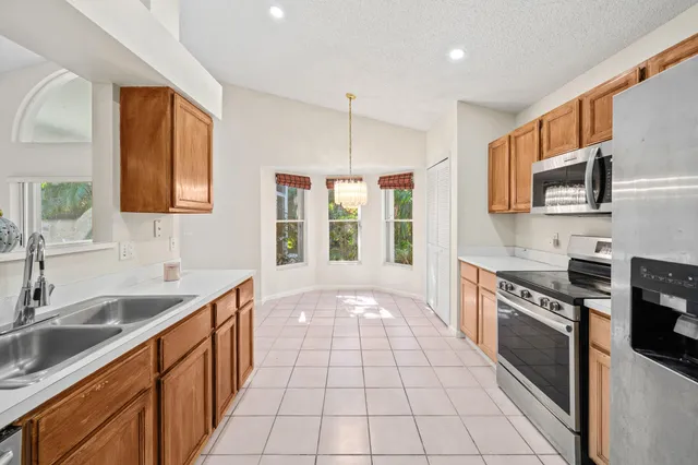 a kitchen with stainless steel appliances granite countertop a refrigerator and a sink
