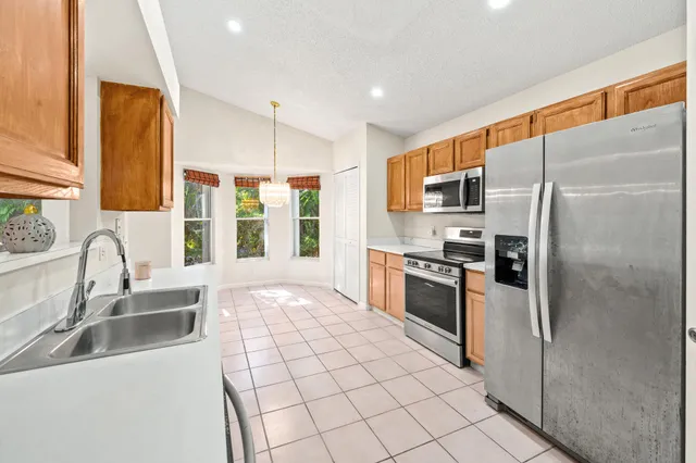 a kitchen with stainless steel appliances granite countertop a refrigerator stove and sink