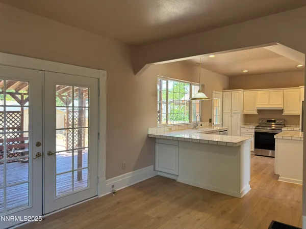a kitchen with stainless steel appliances granite countertop a stove and a large window