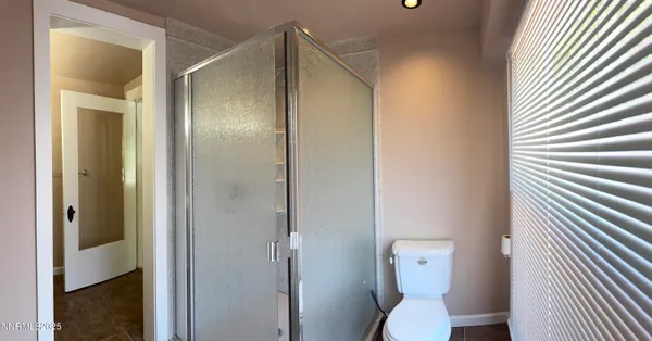 a bathroom with a toilet and a shower