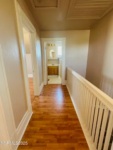 a view of a hallway with wooden floor and staircase