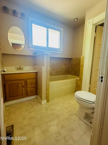 a bathroom with a toilet a sink a mirror and bathtub