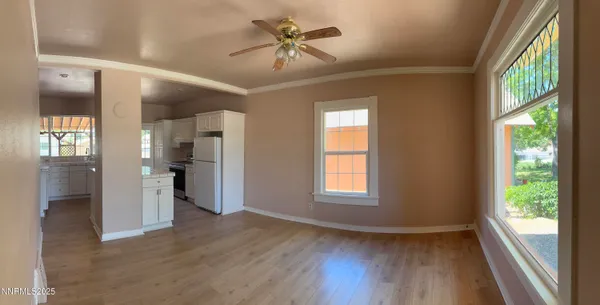 a view of an empty room with a window and wooden floor