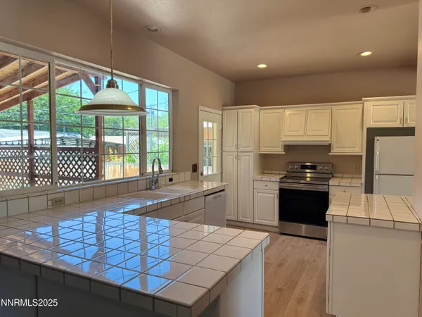 a kitchen with stainless steel appliances granite countertop a stove a sink and a refrigerator