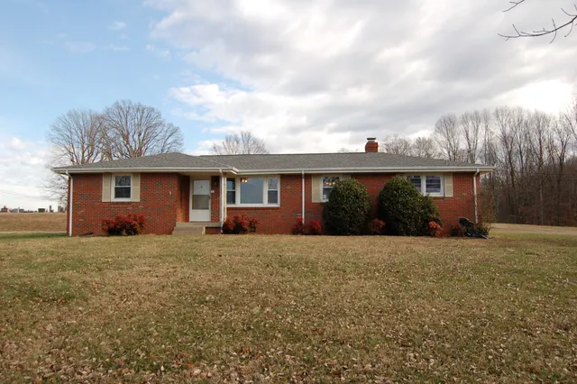 a front view of a house with a garden and yard