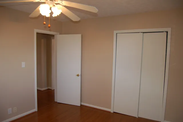a view of a hallway with wooden floor and a chandelier