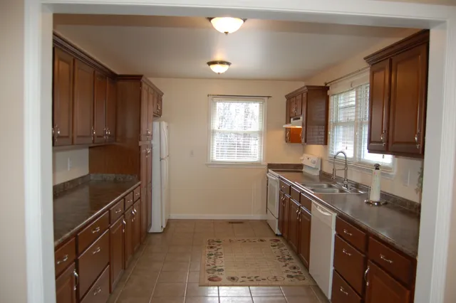 a kitchen with granite countertop a sink stove and cabinets