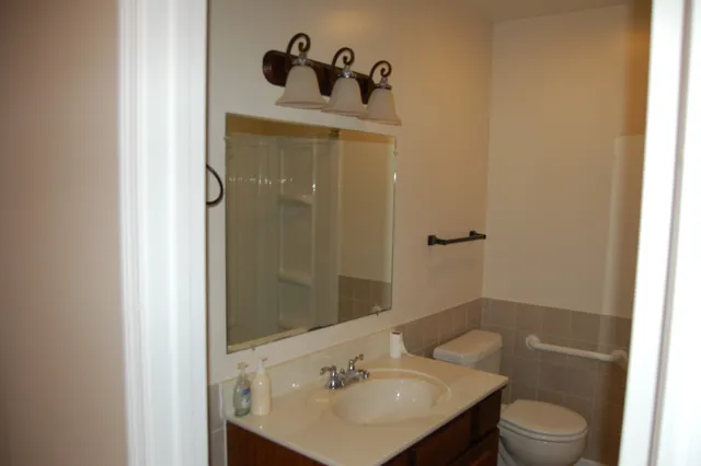 a bathroom with a sink a toilet and shower