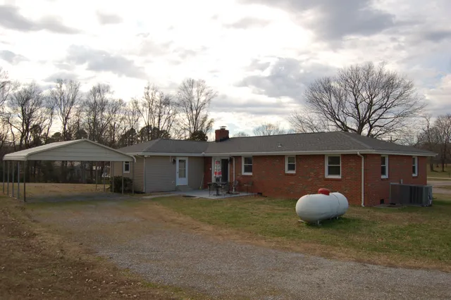 a view of a house with a backyard and porch