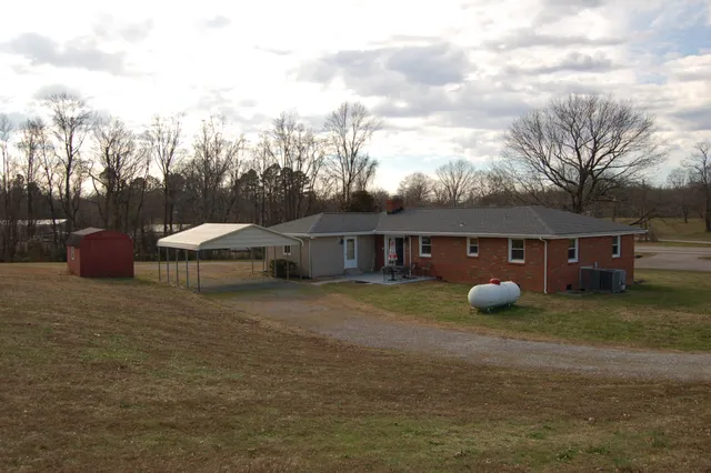 a view of a house with backyard and trees