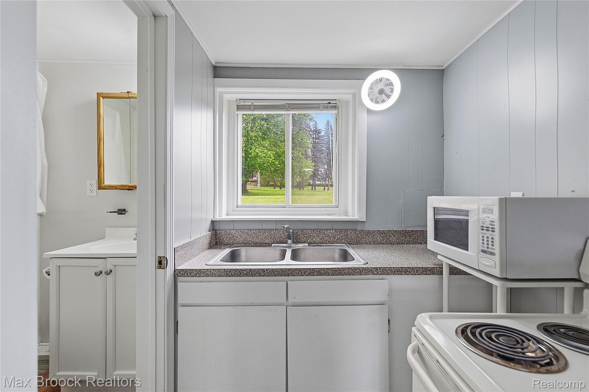 1392 Maple Grove Road Lapeer, MI 48446 - Photo 32 of 70 Kitchen featuring white appliances, crown molding, white cabinets, and wooden walls