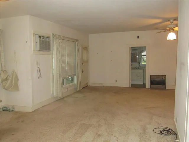 an empty room with a ceiling fan and window