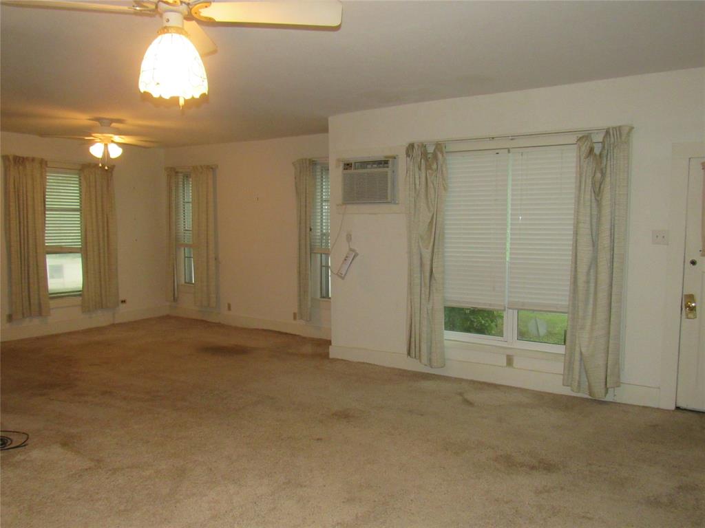 101 East Murray Street Denison, TX 75021 - Photo 13 of 32 an empty room with a ceiling fan and window